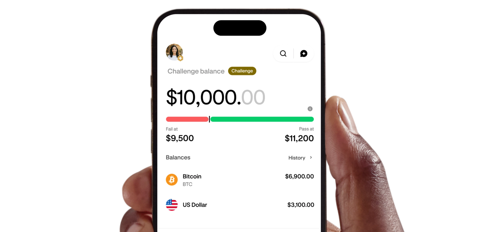Hand holding a phone displaying a funded trading account dashboard